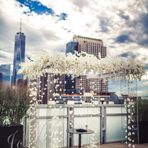 photo: bride and groom holding hands on indoor balcony looking out over the reception